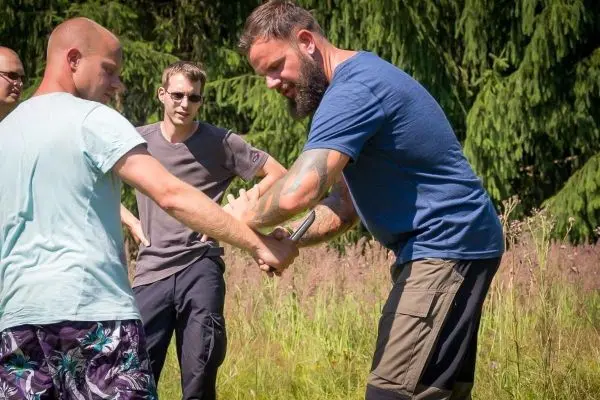 Zwei Personen üben eine Technik zur Handbefreiung im Freien