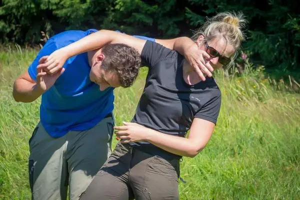 Zwei Personen üben eine Technik zur Unterstützung in einer Notlage im Freien