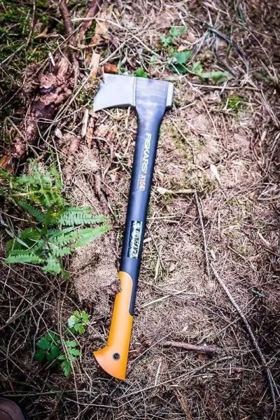 Axt liegt auf dem Boden zwischen Gras und Erde
