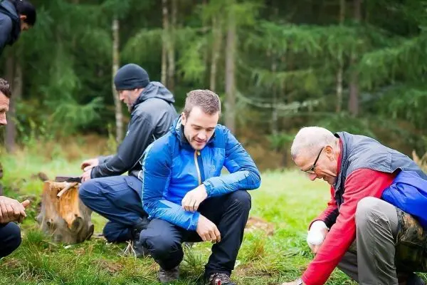 Gruppenmitglieder arbeiten am Boden, um Materialien für ein Projekt zu sammeln