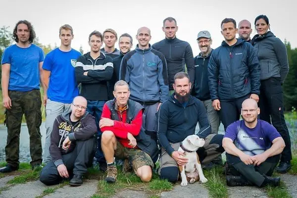 Gruppierung von Teilnehmern in Outdoor-Bekleidung, einige knien, andere stehen