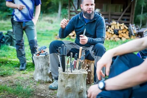 Messer stecken in einem Baumstumpf, während jemand darüber spricht