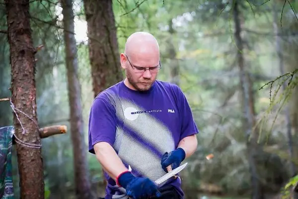 Messer wird in der Hand gehalten, während Holz bearbeitet wird