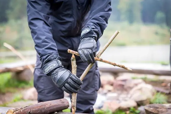Person verbindet Äste mit den Händen
