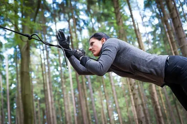 Person zieht an einem Seil im Wald