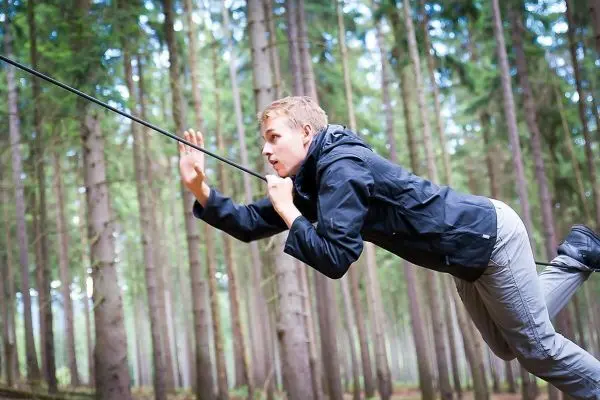 Selbstgebaute Seilquerung wird von einer Person überquert