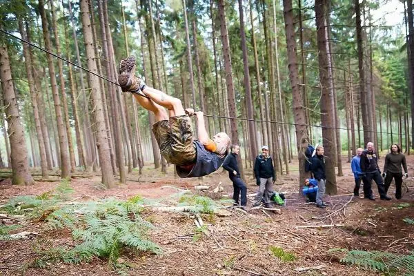 Selbstgebaute Seilquerung wird von einer Person überquert, andere beobachten