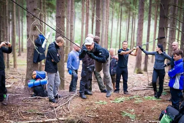 Selbstgebaute Seilquerung wird von einer Person überquert, während andere beobachten