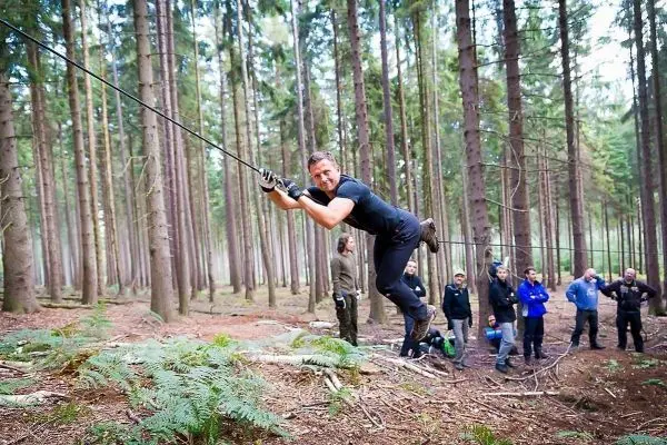 Selbstgebaute Seilquerung wird von einer Person überquert, Zuschauer im Hintergrund