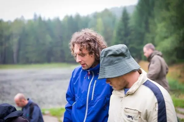 Zwei Personen in Outdoor-Bekleidung betrachten etwas am Boden