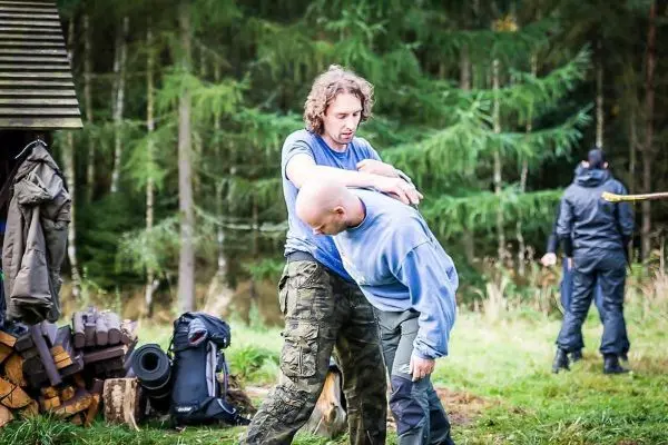 Zwei Personen üben eine Selbstverteidigungstechnik im Freien