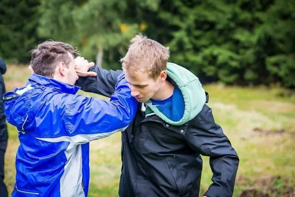 Zwei Personen üben eine Selbstverteidigungstechnik im Freien aus