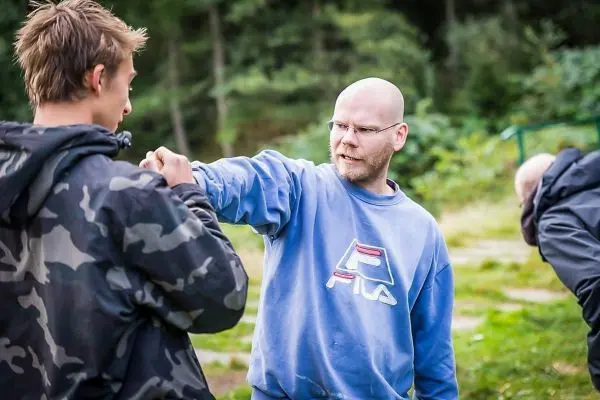 Zwei Personen üben eine Technik im Nahkampftraining im Freien