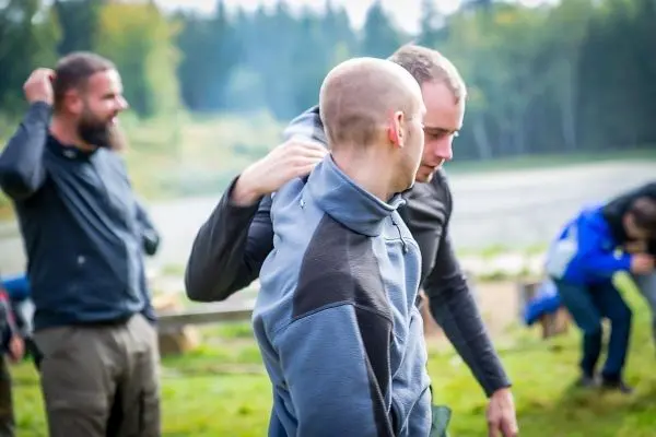 Zwei Personen üben eine Technik zur Selbstverteidigung im Freien