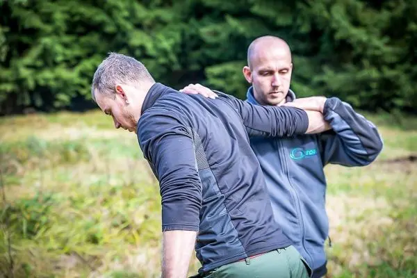 Zwei Personen üben eine Technik zur Unterstützung in einer Outdoor-Umgebung