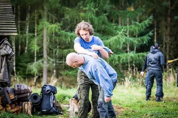 Zwei Personen üben eine Technik zur Unterstützung in einer Outdoor-Umgebung