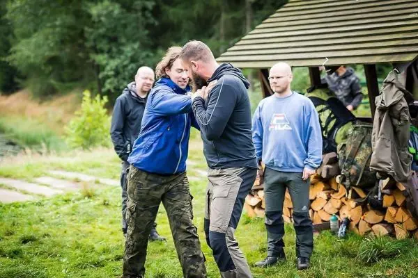 Zwei Personen üben einen Nahkampfgriff, während andere zuschauen