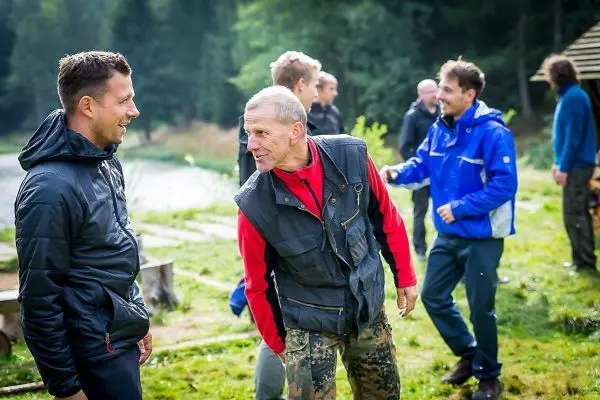 Zwei Personen unterhalten sich, während andere im Hintergrund stehen