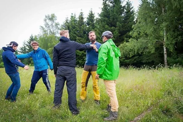 Gruppe von fünf Personen übt im Freien eine Technik