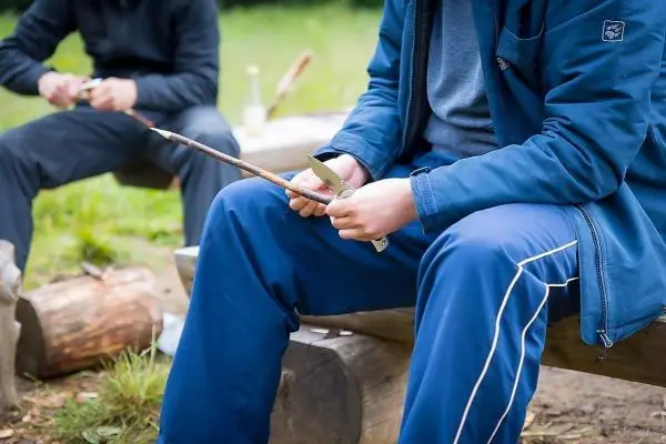 Holzstück wird mit einem Messer bearbeitet