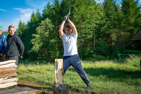Person schlägt mit einer Axt auf einen Holzblock