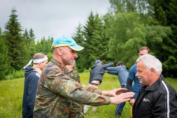 Person zeigt einer anderen Person eine Technik im Freien
