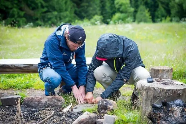 Zunder wird auf einem Stein unter einem kleinen Bodenfeuer vorbereitet
