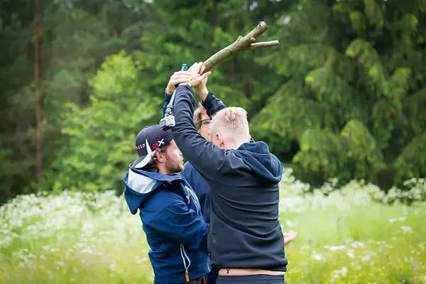 Zwei Personen halten einen Stock über ihren Köpfen und ziehen daran