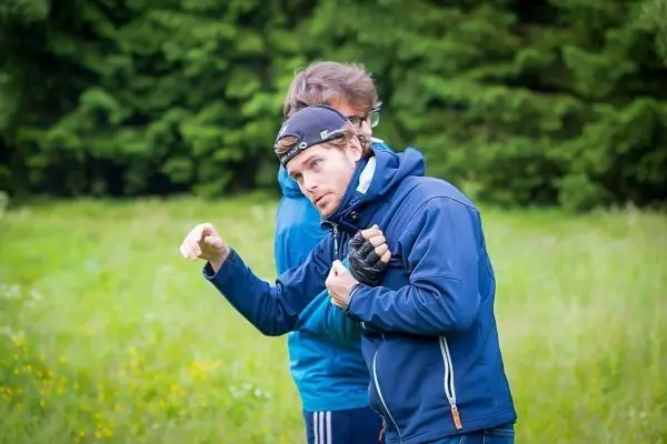 Zwei Personen stehen in einer Wiese und diskutieren