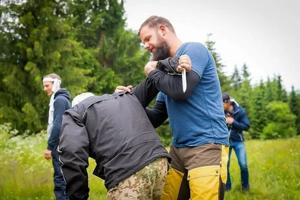 Zwei Personen üben eine Selbstverteidigungstechnik im Freien
