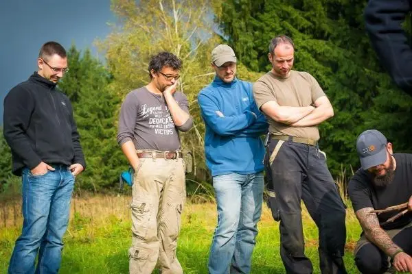 Fünf Personen beobachten konzentriert eine Aktivität im Freien