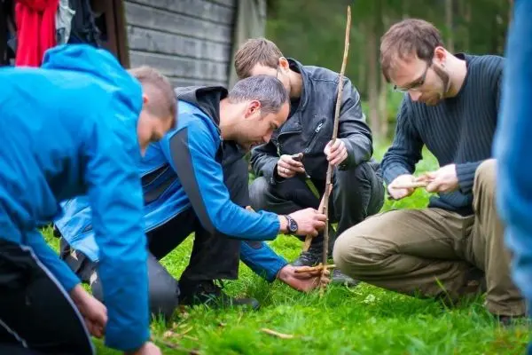 Gruppierung von Personen bearbeitet Holzstücke auf einer Wiese