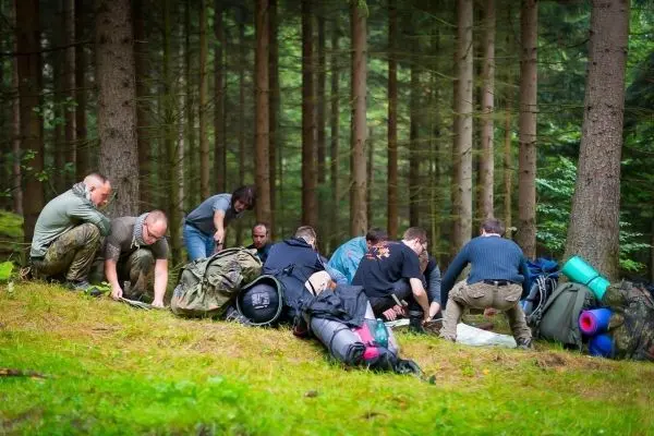 Gruppierung von Personen sortiert Ausrüstung auf dem Waldboden