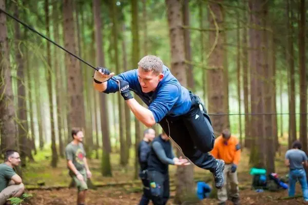 Selbstgebaute Seilquerung wird von einem Teilnehmer überquert