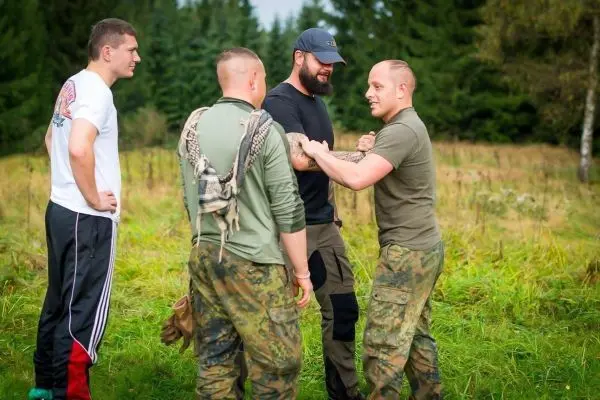 Vier Personen stehen auf einer Wiese und diskutieren miteinander