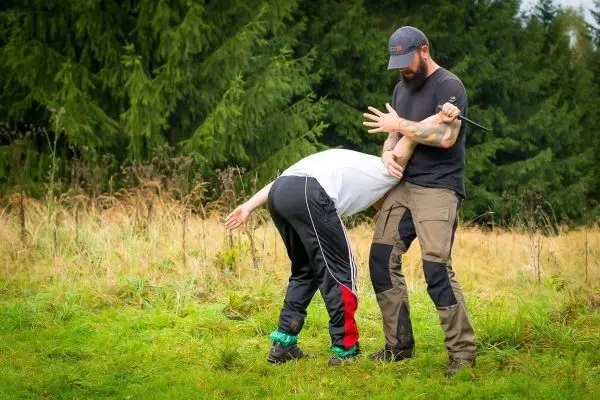 Zwei Personen üben eine Selbstverteidigungstechnik im Freien