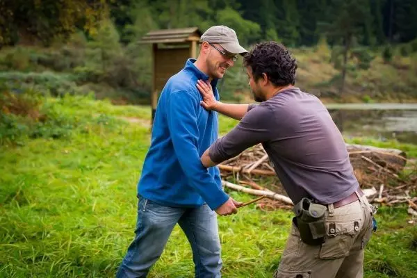 Zwei Personen üben eine Selbstverteidigungstechnik im Freien