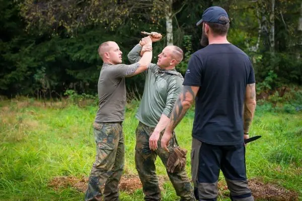 Zwei Personen üben eine Selbstverteidigungstechnik mit einem Messer