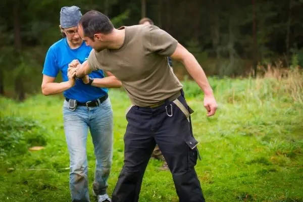 Zwei Personen üben eine Technik zur Handbefreiung im Freien