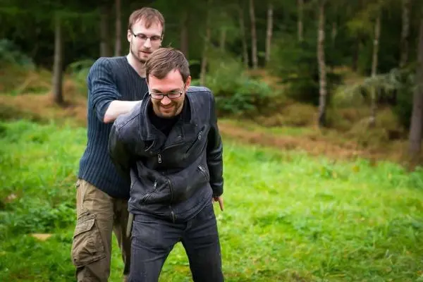 Zwei Personen üben eine Technik zur Handfesselung im Freien aus