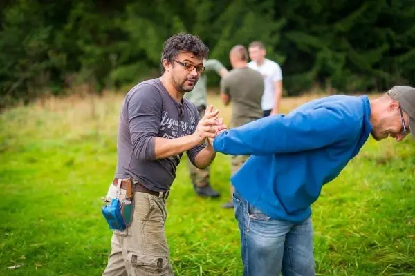 Zwei Personen üben eine Technik zur Kontrolle des Arms im Freien