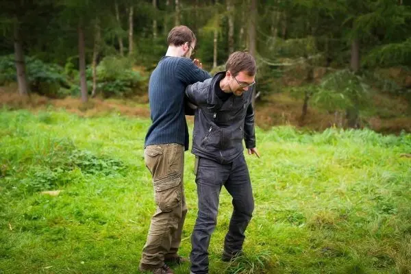 Zwei Personen üben eine Technik zur Kontrolle des Gegners im Freien