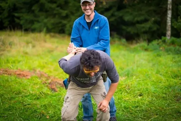 Zwei Personen üben eine Technik zur Kontrolle in einer Wiese