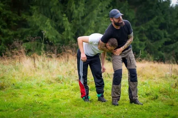 Zwei Personen üben eine Technik zur Kontrolle in einer Wiese