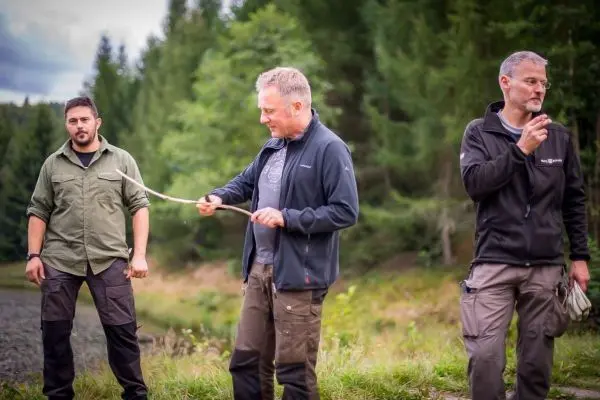 Drei Personen stehen im Freien und halten Seil in der Hand