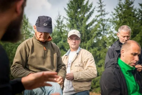 Gruppe von Personen in einem Wald, die sich auf eine Aktivität vorbereiten