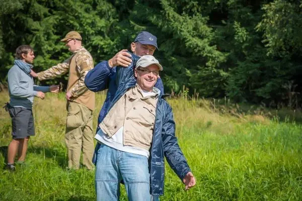 Gruppendynamik im Freien, eine Person umarmt eine andere in einer Wiese