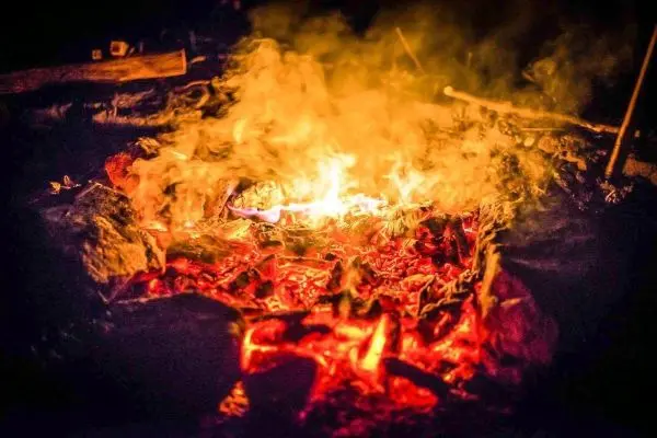 Kleine Flamme mit glühenden Kohlen und Rauchentwicklung