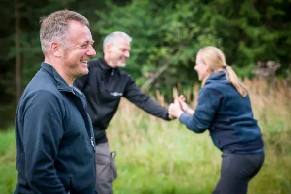 Lächelnde Personen interagieren in einer natürlichen Umgebung