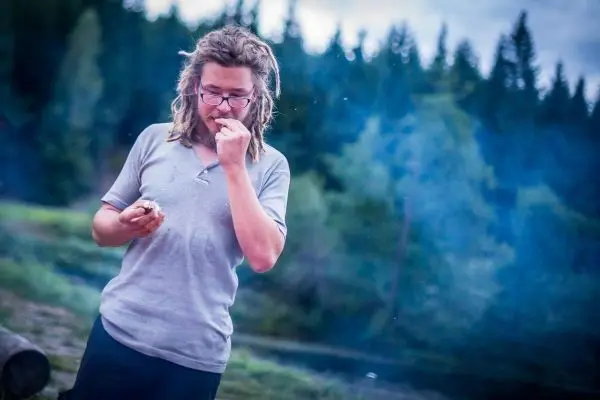 Mann hält etwas in der Hand und schaut nachdenklich in die Ferne